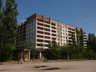 Abandoned block of flats surrounded by green trees in the ghost city of Pripyat, Chernobyl Exclusion Zone, Ukraine (June 2019)