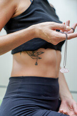 Fototapeta premium Woman with matching tattoo holding pink crystal in her hand