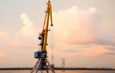 View of the river cranes at sunset. Sand mining on the River Dnipro.