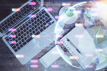 Double exposure of map hologram drawing over study table background with computer. Concept of international network. Top view.