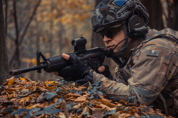 Fototapeta premium portrait of a soldier with a gun in the forest of Battlefield/army uniform with a weapon.