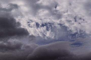 Obraz premium gray clouds covering a blue sky with a curtain of white clouds.