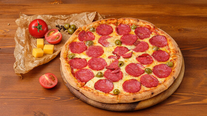 Tasty pizza pepperoni on wooden brown background