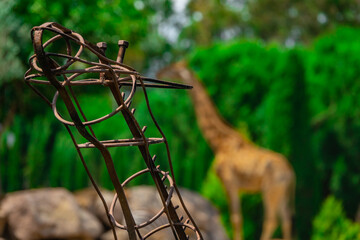 The giraffe matel statue behind blurred background.