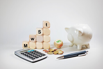 Calculator, piggy bank and dices with German text MwSt (value added tax), reduction from 19% to...