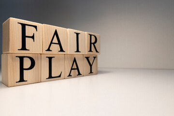 Fair play word from wooden cubes. Spotlight and white background. - obrazy, fototapety, plakaty