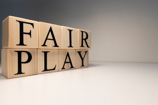 Fair play word from wooden cubes. Spotlight and white background.