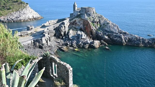 Portovenere, Liguria, Italy. June 2020. Enchanting seascape with the small promontory that houses the church of San Pietro. The crystal clear waters surround the rocky promontory.
