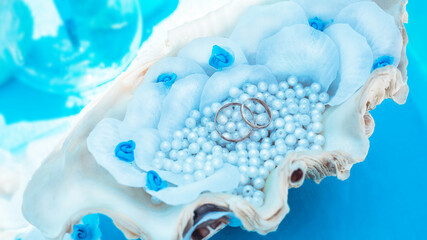 Wedding rings in a shell with pearls.