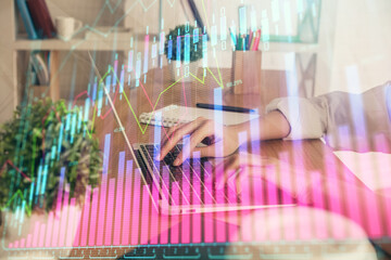 Double exposure of woman hands typing on computer and forex chart hologram drawing. Stock market invest concept.