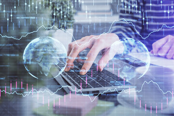 Double exposure of woman hands typing on computer and forex chart hologram drawing. Stock market...