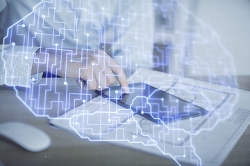 Double exposure of man's hand holding and using a digital device and brain hologram drawing. Data concept.