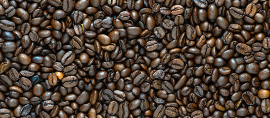 Fresh coffee beans scattered as a background or texture.