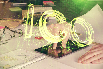 Double exposure of man's hands holding and using a phone and crypto currency blockchain theme...