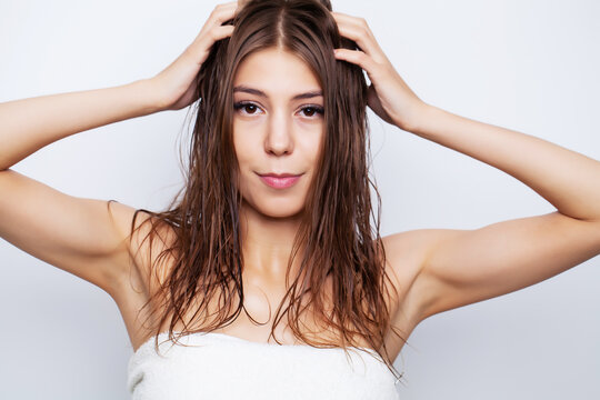Young woman with luxurious hair applies conditioner for hair care