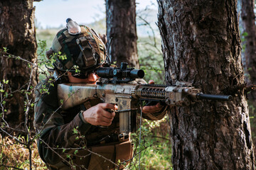	
Soldier in a forest hiding in a foliage. Full equipment. soldier concept	
