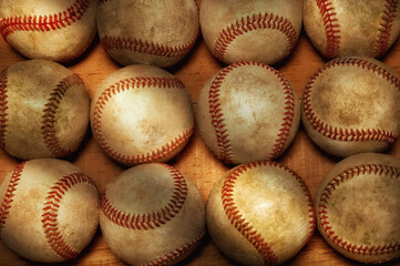 Flat Lay Baseball Still life. A high angle shot of a dozen used baseballs on a wood surface with warm side light.