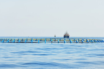 Fish farm in an open Mediterranean sea, fishing boat (small ship) close-up, Spain. Food industry,...