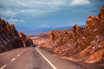 Road leading to San Pedro de Atacama with beautiful red coloured rocks and white coloured salt layer on the side #1