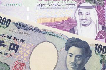 A one thousand Japanese yen bank note, close up in macro with a five riyal bank note from Saudi...
