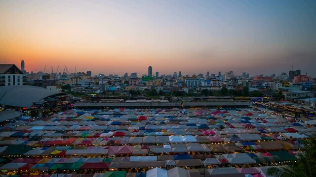 day to night time lapse of Train Night Market Ratchada (Talad Rot Fai) at sunset in Bangkok, Thailand