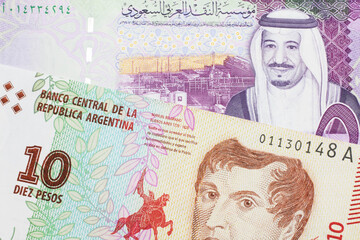 A ten peso bill from Argentina, close up in macro with a colorful five riyal bank note from Saudi Arabia