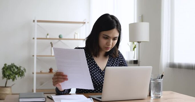 Asian secretary woman do paperwork use laptop working sit at workplace desk in light office room. Paralegal do draft contract agreement, makes report preparation, having busy fruitful workday concept