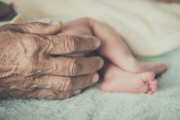 Grandma's hand holding Asian grandson
