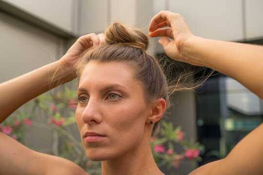 Woman Fixing Her Hair In The Bun