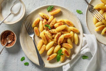 Yummy potato dumplings with cinnamon, sugar and mint leaves