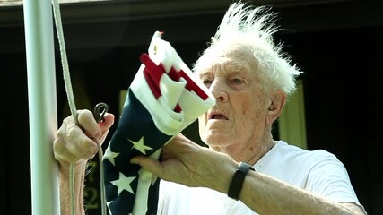 Close shot of 93-year-old World War II Navy veteran Raises the American Flag outside his house in Oklahoma