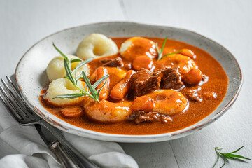 Tasty silesian noodles with goulash made of beef and vegetables