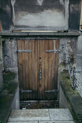 A wooden bench on the side of a building