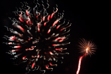 Two red and white abstract firework bursts created using intentional camera movement
