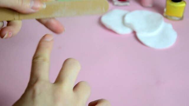 Close up image of woman using nail buffer when doing manicure, polishing nails at home. Smiling lady testing new beauty products and modern cosmetics, doing morning makeup or daily nail care routine