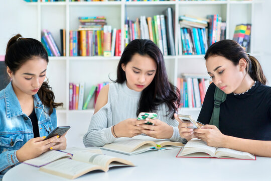 Group of lazy teenage girls studying in the library - Powered by Adobe