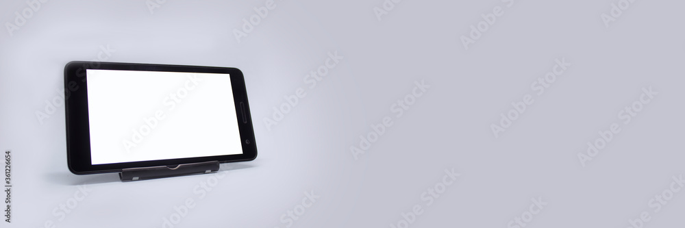 Poster mock up tablet with white display on a light background.