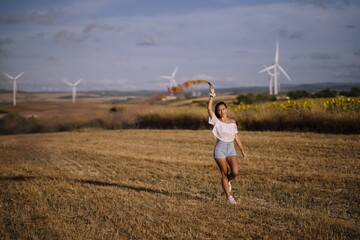 Horizontal shot of a young caucasian female posing with an smoke bomb in a field