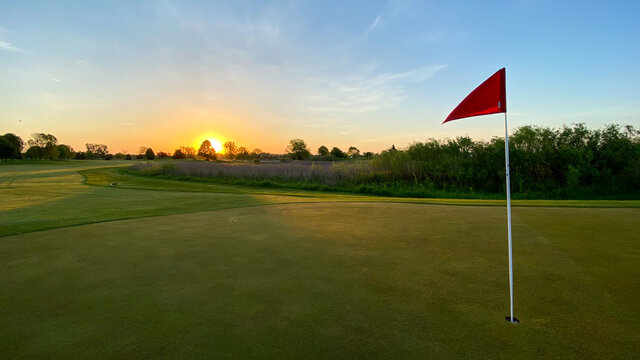 sunrise on golf course red flag golf green