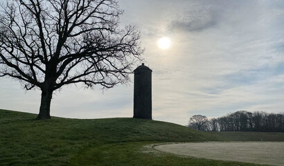 Fototapeta na wymiar old stone silo on golf course early morning fog hazy sun