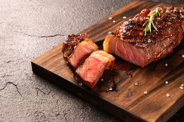 Fresh grilled meat. Grilled beef steak medium rare on wooden board. Top view.