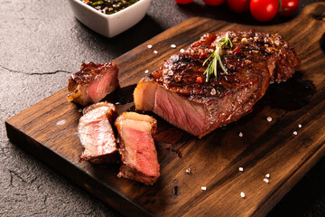 Fresh grilled meat. Grilled beef steak medium rare on wooden board. Top view.