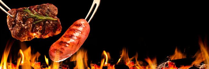 Beef steak and sausage falling on the grill with fire. Brazilian barbecue.
