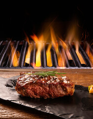Beef steak on the cutting board with grill with fire background. Brazilian barbecue.