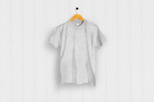 Heather gray T-shirt hung on the white wood wall
