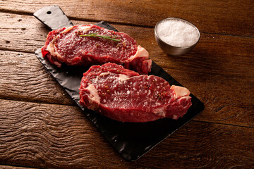 Raw ancho meat  for cooking on dark cutting board. Wooden background.