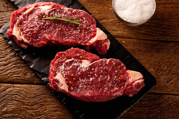Raw ancho meat  for cooking on dark cutting board. Wooden background.