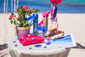 Decorative table with wedding accessories settings, decoration, flowers and decor for beach outdoor tropical destination wedding matrimonial marriage ceremony.Love. family and unity concept