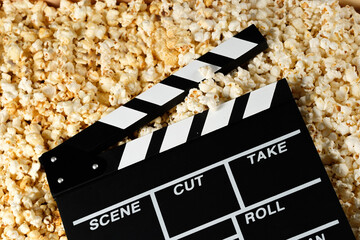 Clapper board with popcorn. Movie concept. Popcorn cracker on the background. Close-up. Copy space.