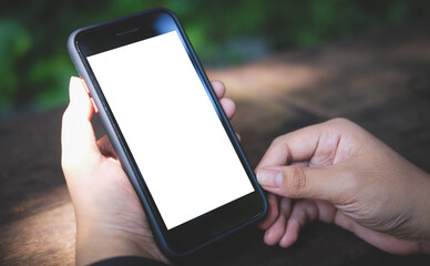 Mock up smartphone of hand holding black mobile phone with blank white screen.